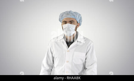 Mature surgery in a mask walking Front view on gradient background. Stock Photo