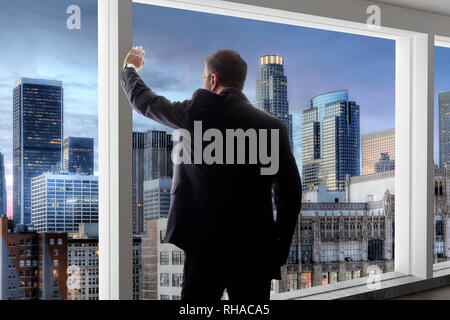 Middle aged businessman looking out a bright office window in Los Angeles and thinking Stock Photo