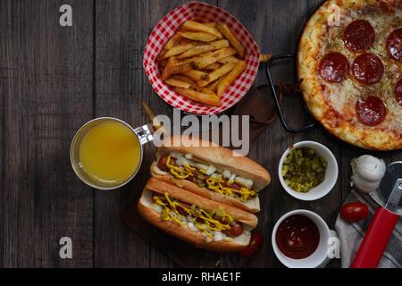 Party game day food Homemade Pizza hot dogs fries juice and dips - Super bowl food concept overhead view