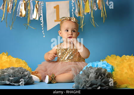 studio shot, a little girl on blue background in beautiful festive dress Stock Photo