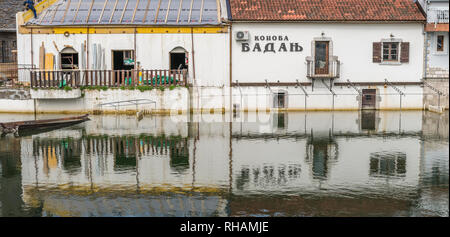 Virpazar, Montenegro - April 2018 : Old buildings reflected in the lake Skadar in Virpazar town Stock Photo