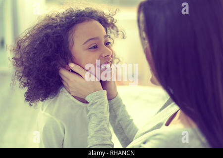 Loving mother holding face of her daughter in her hands. Stock Photo
