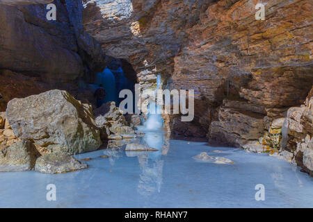 Frozen waterfall in a gorge high in the mountains Stock Photo