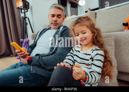 Tall handsome grey-haired father in sportswear looking thoughtful Stock Photo