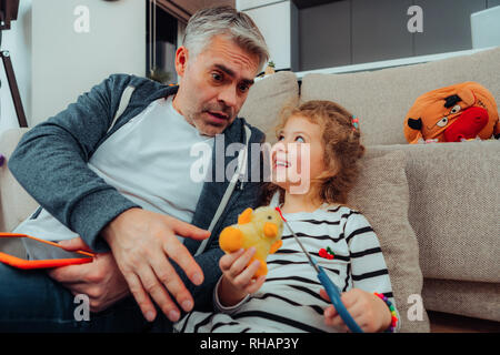 Handsome grey-haired tall father with a red watch on his hand looking scared Stock Photo