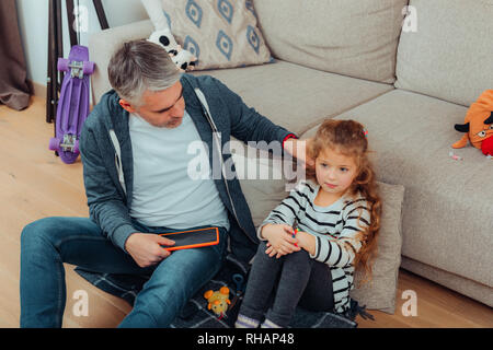 Handsome grey-haired tall father with a red watch on his hand looking angry Stock Photo