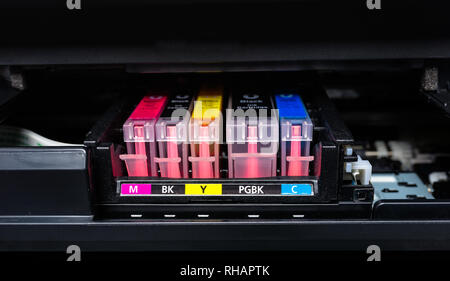 Close-up shot of a CMYK ink cartridges in a color printer. Stock Photo