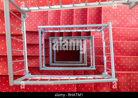 Top view symmetric stairwell with red carpet and steel parapet Stock Photo