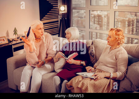 Delighted nice aged women discussing interesting books Stock Photo