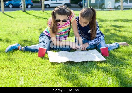 Young cute girls teens with map of european city outdoors, copy space Stock Photo