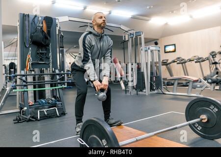 Adult handsome bearded man doing physical exercises in the gym. Sport rehabilitation, age, healthy lifestyle concept Stock Photo