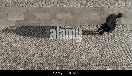 Lisbon, Baixa district, A man casting a long shadow in the afternoon. Stock Photo