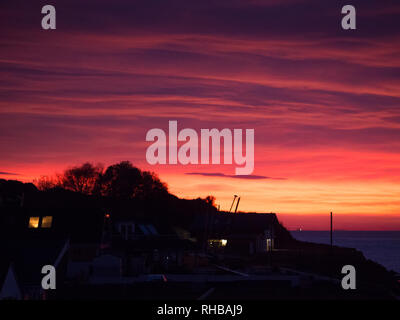 A heavy clouded high contrast striking UK coastal beachside sunset Stock Photo