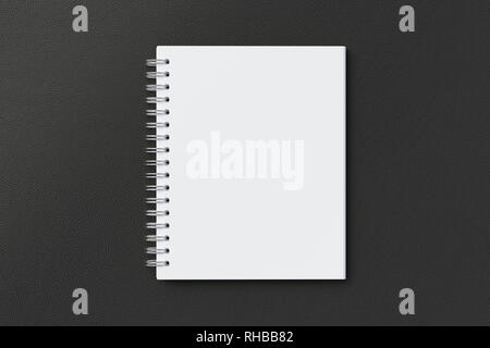 Blank vertical spiral notepad on black background. With clipping path around notebook pages Stock Photo