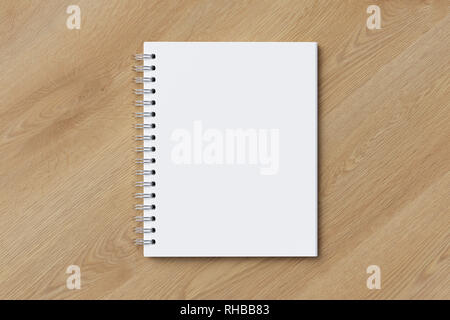 Blank vertical spiral notepad on wooden background. With clipping path around notebook pages Stock Photo