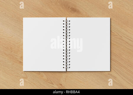 Blank open vertical spiral notepad on wooden background. With clipping path around notebook pages Stock Photo