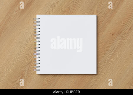 Blank square spiral notepad on wooden background. With clipping path around notebook pages Stock Photo