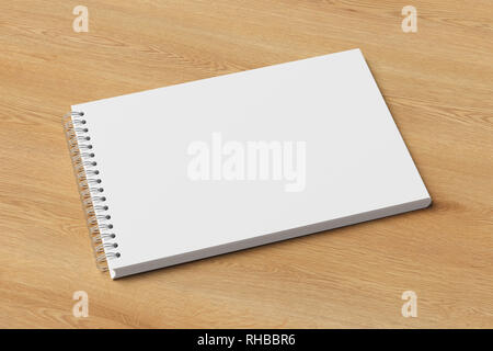 Blank horizontal spiral notepad on wooden background. With clipping path around notebook pages Stock Photo