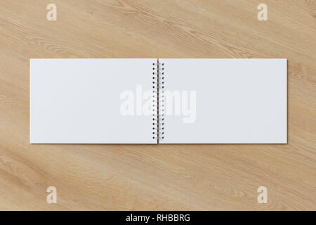 Blank open horizontal spiral notepad on wooden background. With clipping path around notebook pages Stock Photo