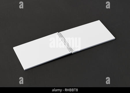 Blank open horizontal spiral notepad on black background. With clipping path around notebook pages Stock Photo