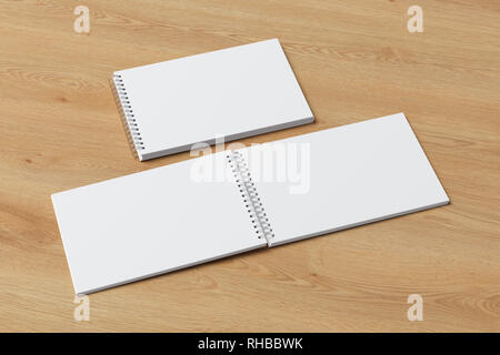 Blank open and closed horizontal spiral notepads on wooden background. With clipping path around notebooks pages Stock Photo