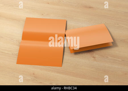 Blank brown open and folded half-folded flyer leaflet on wooden background. With clipping path around brochure Stock Photo
