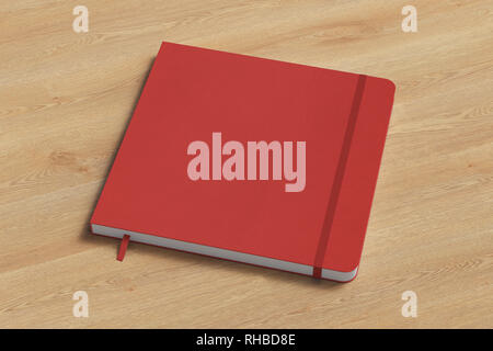 Red square notebook with elastic band on wooden background Stock Photo