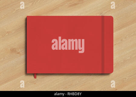 Red horizontal notebook with elastic band on wooden background Stock Photo