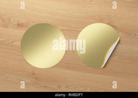 Blank golden round stickers straightened and with folded corner on wooden background. With clipping path around stickers. Stock Photo