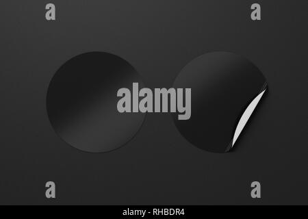 Blank black round stickers straightened and with folded corner on black ...