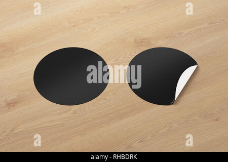 Blank black round stickers straightened and with folded corner on black ...