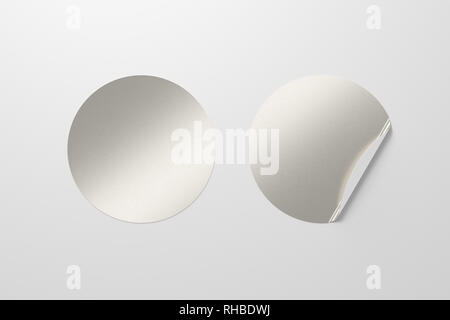 Blank silver round stickers straightened and with folded corner on white background. With clipping path around stickers. Stock Photo