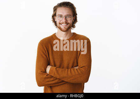 Waist-up shot of satisfied successful male programmer in glasses with beard holding hands crossed over chest in confident self-satisfied pose smiling Stock Photo