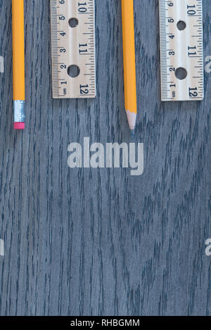 Pencils and rulers on gray wood grain background flat lay arrangement Stock Photo