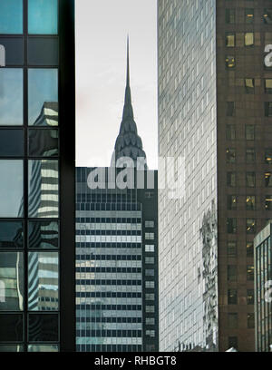 vertical view of the Philadelphia sky line with industrial buildings in the foreground and a woman riding a bicycle in the foreground Stock Photo