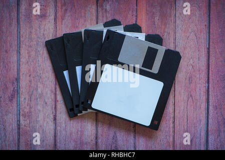 Antique pc diskettes on a brown wooden background Stock Photo