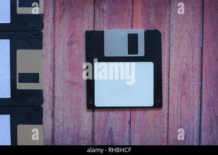 Antique pc diskettes on a brown wooden background Stock Photo