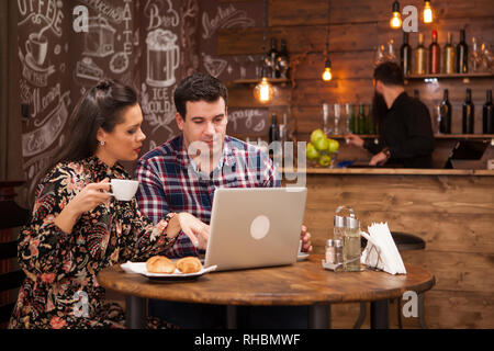 Attractive couple at a business meeting in the restaurant disucssing working moments at lunch time. Hipster pub. Stock Photo