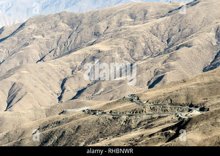 Modern paved mountain road with rugged mountains in the background, Tibet Stock Photo