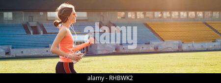 Beautiful teenage girl running in stadium, panoramic banner Stock Photo