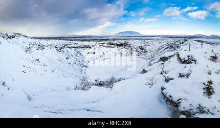 Panoramic view of the Kerid Volcano with snow and ice in the volcanic crater lake in Winter under a clear blue sky. located in the Grímsnes area in so Stock Photo