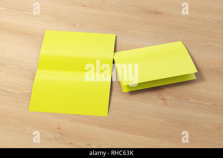 Blank yellow open and folded half-folded flyer leaflet on wooden background. With clipping path around brochure Stock Photo
