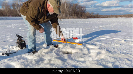 Wisconsin fisherman preparing a tip-up for ice fishing Stock Photo