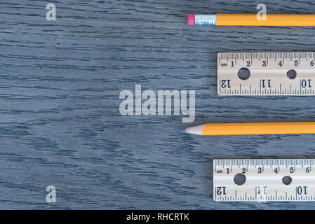 Flat lay of pencils and wood rulers on wood grain background Stock Photo