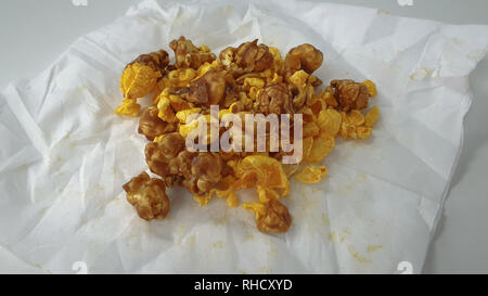 Caramel-flavored popcorn snacks on a tissue at the table Stock Photo