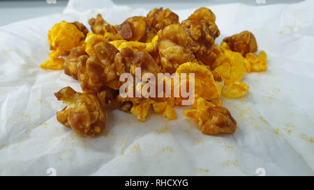 Caramel-flavored popcorn snacks on a tissue at the table Stock Photo