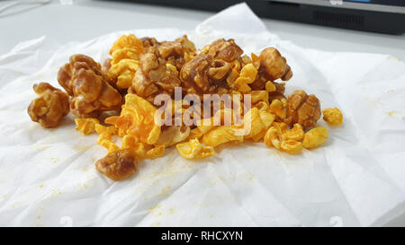 Caramel-flavored popcorn snacks on a tissue at the table Stock Photo