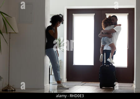 Sad african father hugging little daughter before leaving family Stock Photo