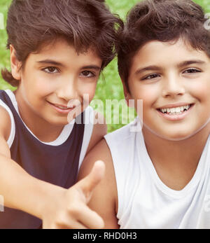 Closeup portrait of a two happy smiling boys, best friends with pleasure spending time together outdoors, enjoying holidays in the summer camp Stock Photo