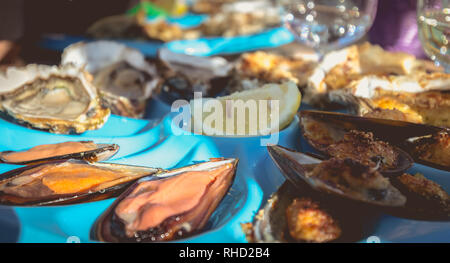 dish of oysters and mussels cooked and raw on a table near the sea in the south of France Stock Photo